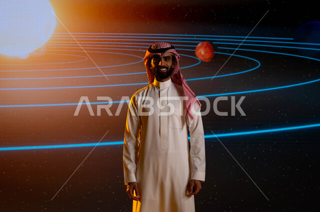 رؤية مستقبلية 2030، رجل اعمال سعودي عربي خليجي يقف امام شاشة الكترونية حديثة، رحلة السعودية نحو الفضاء الخارجي، ايماءات وجه تدل على السعادة، نمو وتطوير قطاع الفضاء في السعودية، خلفية شاشة عرض لمسار حركة الارض والكواكب حول الشمس
