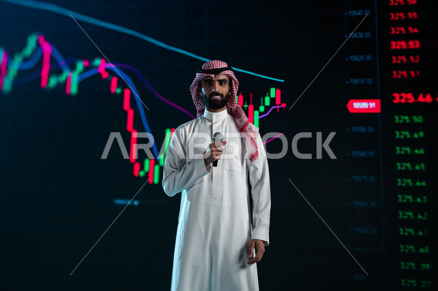 عرض تقديمي للاستثمار المالي وسوق الاسهم، مقترحات ونصائح حول التدوال الإلكتروني، رجل اعمال خليجي سعودي عربي يمسك المايكروفون ويتحدث في مؤتمر اقتصادي سعودي، تحليل البيانات والمعلومات الرقمية، خلفية شاشات الكترونية حديثة لمتابعة صعود وهبوط مؤشر البورصة