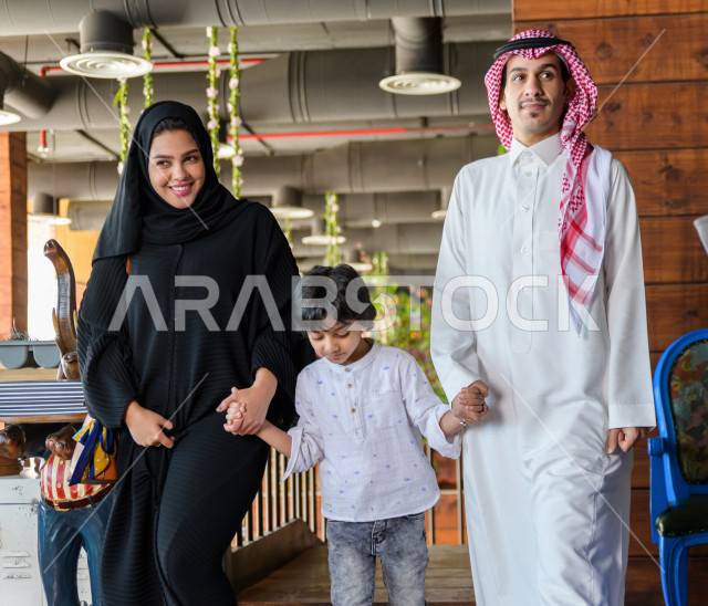 صورة من الأمام لعائلة عربية خليجية سعودية تقوم بالدخول الى المطعم ، قضاء وقتا ممتعا في المطعم ، قضاء أوقات عائلية ترفيهية ، قضاء العطلة مع العائلة ، جلسات فريدة و مميزة ، مطاعم و كافيهات في السعودية