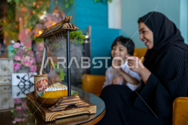 طفل عربي خليجي سعودي يقضي وقته مع والدته في المطعم بايماءات و تعابير وجه تدل على السعادة ، الاحتفال بعيد ميلاد ، قضاء العطلة مع العائلة ، أجواء عائلية ترفيهية ، جلسات فريدة و مميزة ، مطاعم و كافيهات في السعودية