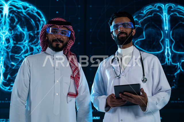 Diagnosis and explanation of disease cases through the tablet, advanced modern centers and hospitals, a Saudi Gulf doctor and man wearing virtual reality glasses, a background of three-dimensional hologram screens for advanced magnetic resonance imaging o