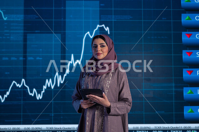خلفية شاشة إلكترونية حديثة لصعود وهبوط مؤشر الأسهم والبورصة، تقديم الأخبار الإقتصادية السعودية ومستجداتها، مذيعة وإعلامية عربية خليجية سعودية تقوم بقراءة الموجز الأخباري بإستخدام التابلت، التغيرات الحاصلة في أسعار السلع والثروات