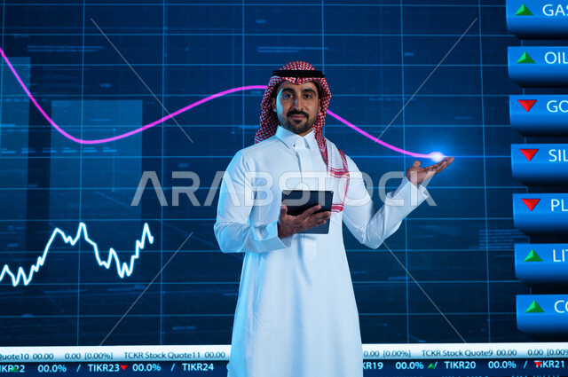 التغيرات الحاصلة في أسعار السلع والثروات، مذيع وإعلامي عربي خليجي سعودي يقوم بتقديم النشرات الإخبارية الإقتصادية، قراءة الموجز الأخباري بإستخدام جهاز التابلت، خلفية شاشة إلكترونية حديثة لصعود وهبوط مؤشر الأسهم والبورصة