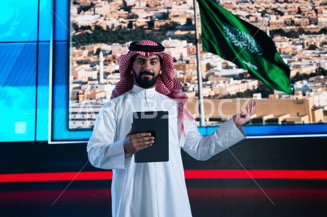 خلفية شاشة إلكترونية لمدن ومعالم السعودية، مذيع عربي سعودي خليجي يقوم بقراءة الموجز الإخباري بإستخدام التابليت، تقديم النشرة الإخبارية، الإحتفال بيوم العلم السعودي وإحياء ذكرى اليوم الوطني، دمج البيئة العملية مع التقنية والتكنولوجيا