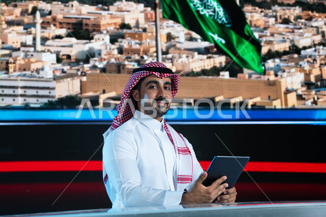 خلفية شاشة إلكترونية لمدن ومعالم السعودية، قراءة الموجز الإخباري بإستخدام التابليت، دمج البيئة العملية مع التقنية والتكنولوجيا، مذيع عربي سعودي خليجي يقوم بتقديم النشرة الإخبارية، الإحتفال بيوم العلم السعودي وإحياء ذكرى اليوم الوطني