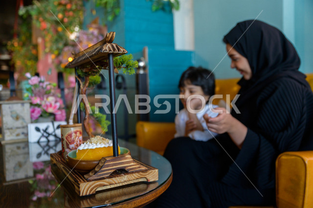 طفل عربي خليجي سعودي يقضي وقته مع والدته في المطعم بايماءات و تعابير وجه تدل على السعادة ، الاحتفال بعيد ميلاد ، قضاء العطلة مع العائلة ، أجواء عائلية ترفيهية ، جلسات فريدة و مميزة ، مطاعم و كافيهات في السعودية