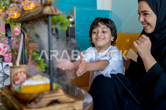 طفل عربي خليجي سعودي يقضي وقته مع والدته في المطعم بايماءات و تعابير وجه تدل على السعادة ، الاحتفال بعيد ميلاد ، قضاء العطلة مع العائلة ، أجواء عائلية ترفيهية ، جلسات فريدة و مميزة ، مطاعم و كافيهات في السعودية