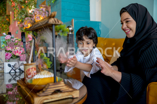 طفل عربي خليجي سعودي يقضي وقته مع والدته في المطعم بايماءات و تعابير وجه تدل على السعادة ، الاحتفال بعيد ميلاد ، قضاء العطلة مع العائلة ، أجواء عائلية ترفيهية ، جلسات فريدة و مميزة ، مطاعم و كافيهات في السعودية