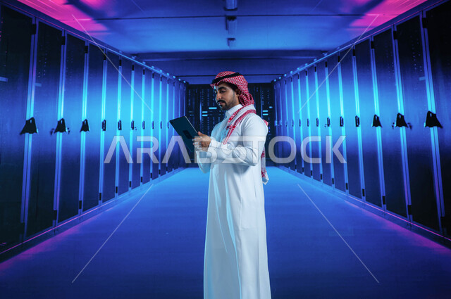 Preserving and storing information for site users, the concept of cloud storage technology, a Saudi Arabian Gulf man who supervises and manages data center data using a tablet, giant internet servers, a 3D hologram background for the server room and serve