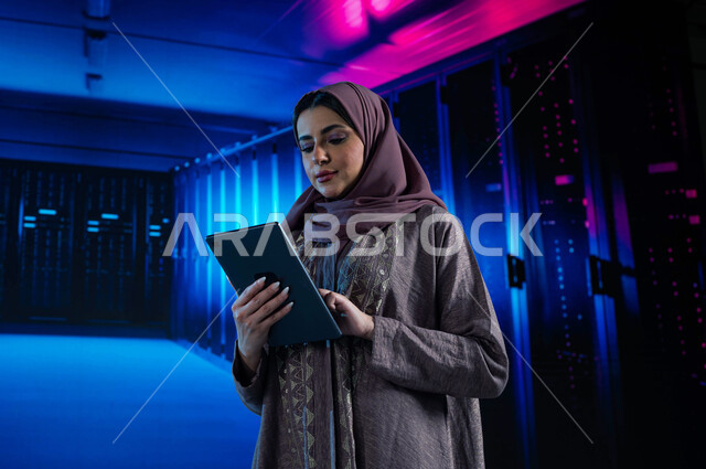 Investing Saudi expertise in building advanced and modern data centers, a Saudi Arab Gulf woman using a tablet to supervise and manage the data and information of the Data Center, the concept of cloud storage technology, a 3D hologram background for the s