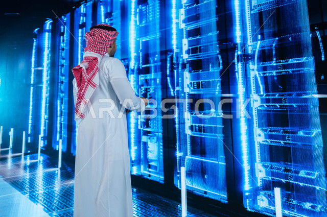Facilitating access to information through database systems, benefiting from Saudi expertise in developing the data center, a Saudi Arabian Gulf man who supervises and controls the data center using a tablet, a 3D hologram background for the servers and s