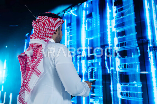 Facilitating access to information through database systems, a Saudi Arabian Gulf man who supervises and controls the data center using a tablet device, benefiting from Saudi expertise in developing the data center, a three-dimensional hologram background