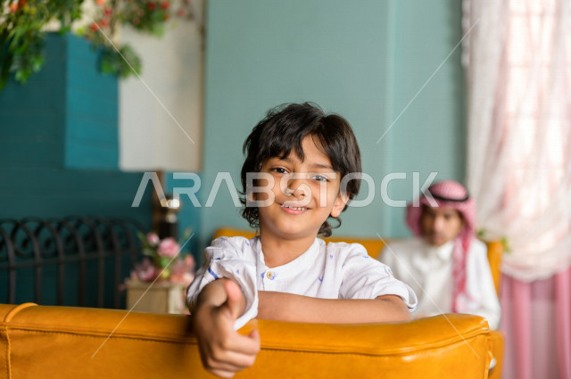 طفل عربي خليجي سعودي يقضي وقته مع والده في المطعم بايماءات و تعابير وجه تدل على السعادة ، قضاء العطلة مع العائلة ، أجواء عائلية ترفيهية ، جلسات فريدة و مميزة ، مطاعم و كافيهات في السعودية