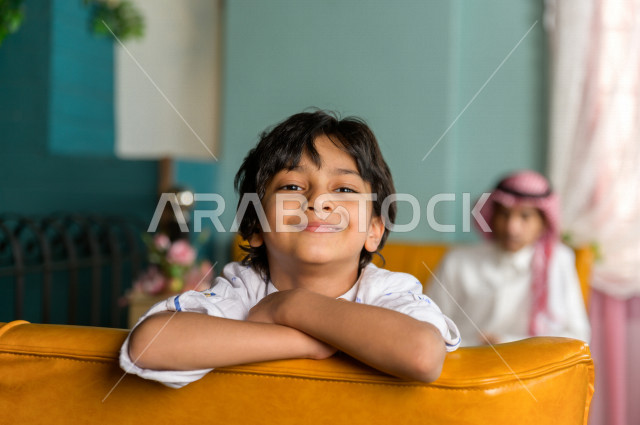 طفل عربي خليجي سعودي يقضي وقته مع والده في المطعم بايماءات و تعابير وجه تدل على السعادة ، قضاء العطلة مع العائلة ، أجواء عائلية ترفيهية ، جلسات فريدة و مميزة ، مطاعم و كافيهات في السعودية