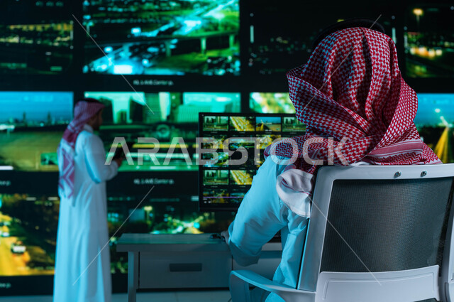 مركز الاداره والإشراف على أمن أحياء ومناطق السعوديه ,رؤية ٢٠٣٠, كاميرات إلكترونيه متطورة ، القيام بمراقبة الحركه المروريه في طرق وشوارع مدينة الرياض، خلفية شاشات حديثه ،صورة من الخلف لفريق عمل عربي خليجي سعودي