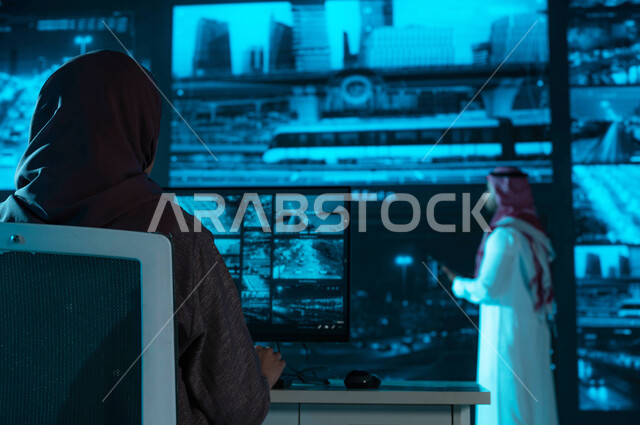 خلفية شاشات حديثه ،صورة من الخلف لفريق عمل يقوم بمراقبة الحركه المروريه في طرق وشوارع مدينة الرياض، كاميرات إلكترونيه متطورة ، مركز الاداره والإشراف على أمن أحياء ومناطق السعوديه، رؤية ٢٠٣٠