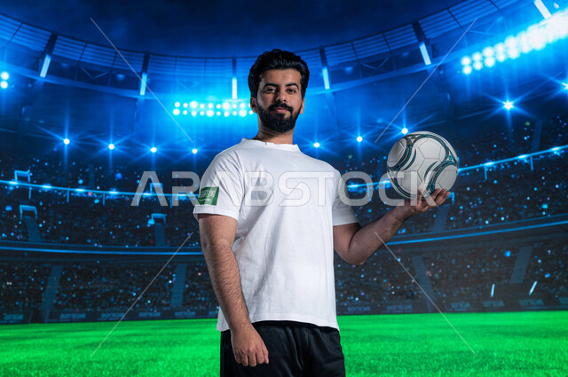 النظر الى الكاميرا, مباراة كرة القدم٢٠٢٣, اولمبياد كرة القدم السعودي, فريق المنتخب الوطني السعودي, ممارسة هواية و رياضة اللعب بالكرة , مونديال السعوديه ، نهائيات كأس العالم فيفا، صوره أمامية مقربة للاعب عربي خليجي سعودي يحمل بيده كرة لقدم