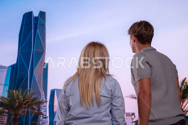 The engineering art of the towers and skyscrapers, a close-up of the back of foreign visitors standing in front of the architectural and economic financial towers, famous tourist places, urban growth and development, new neighborhoods in Riyadh, King Abdu
