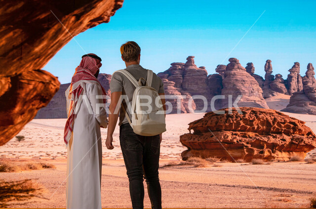 صورة من الخلف لزائر اجنبي مع رجل عربي سعودي يقفان امام القمم والمرتفعات الجبلية الصخرية ,دليل سياحي للسياح, انشطه و فعاليات ترفيهيه سياحية في السعودية، معالم قديمة أثرية تاريخية عريقة ، فتح ابواب السياحه السعودية، موقع أثري في اليونسكو