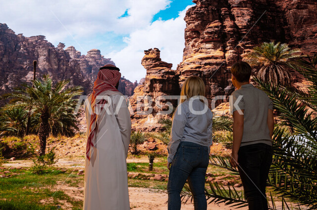 The tourist guide for tourists, opening the doors of Saudi tourism, a picture from the back of foreign visitors with a Saudi Arabian Gulf tour guide enjoying the distinct mountainous nature in the Al-Ula region in Saudi Arabia, the famous historical touri