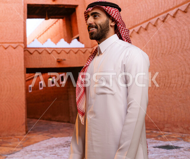 ايماءات تدل على السرور و السعادة, مركز الملك عبد العزيز (قصر المربع) ،معالم تاريخية وطنية سياحية ثقافية في السعودية, رجل عربي خليجي سعودي مبتسم يرتدي الثوب والشماغ السعودي ينظر الى شيء ما، الوقوف في المتحف الوطني السعودي التاريخي في مدينة الرياض