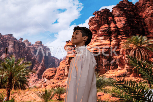 أبرز المعالم التاريخية الأخاذة, ايماءات تدل على الفرح والسعادة، صورة مقربة لولد عربي خليجي سعودي يرتدي الثوب التقليدي يقوم بزيارة موقع أثري في اليونسكو، زراعة النباتات و أشجار النخيل في الأماكن السياحيه المشهوره في محافظة العلا في السعوديه