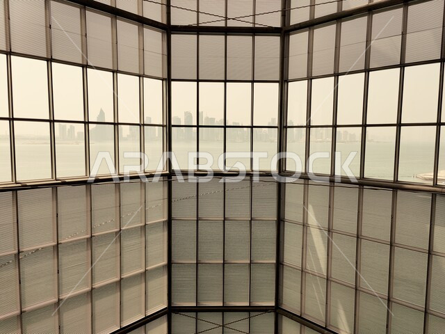 الجدار الزجاجي لللطابق السفلي في المتحف الإسلامي للفنون في العاصمة القطرية الدوحة, أولى مشاريع متاحف قطر, المؤسسات الرائدة في العالم للفن الإسلامي, الفن الهندسي المعماري و الأثاث و الديكور الداخلي للمتحف.