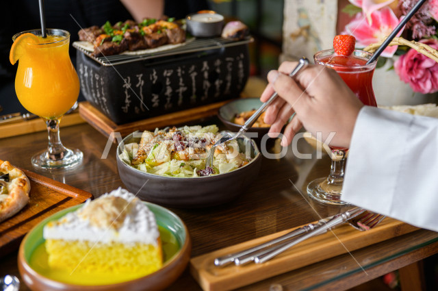 صورة مقربة لمائدة طعام خاصة بزوجين عربيين خليجيين سعوديين ، يجلسان على مائدة الطعام و يتناولان الطعام في المطعم ، قضاء اجواء رائعة  في المطعم ، تشكيلة متنوعة من أصناف الطعام و الماكولات الشهية على الطاولة ، جلسات فريدة و مميزة ، مطاعم و كافيهات في السعودي