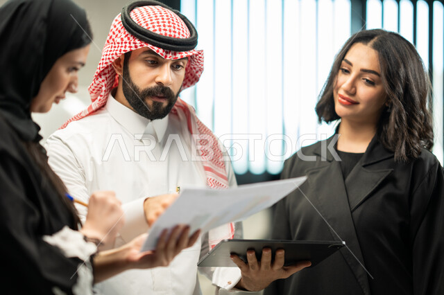 مفهوم الإدارة المتعاونة، شركات ومكاتب خليجية، فريق عمل عربي سعودي خليجي في مقر الشركة يناقشون مهام العمل، مهن ووظائف سعودية، الوحدة والعمل الجماعي لتحقيق أهداف الشركة وحل المشكلات.