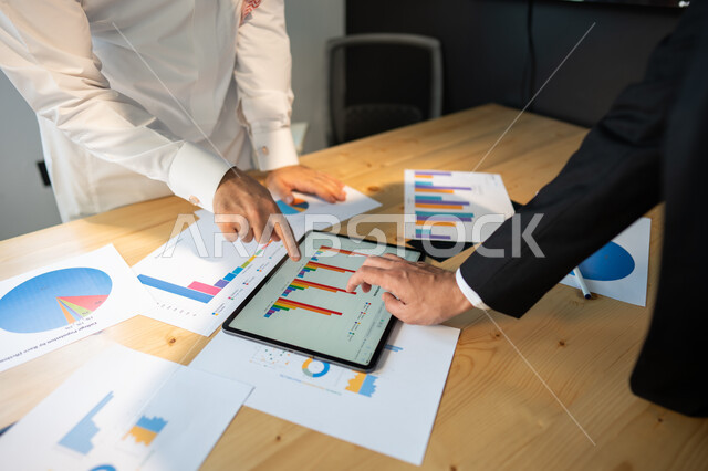 بيانات إنجاز وتحقيق اهداف الشركة، صورة علوية عامودية مقربة لاجتماع رجال أعمال عربيين سعوديين خليجيين داخل مقر الشركة، مفهوم الإدارة المتعاونة، جمع بيانات البورصه وسوق الأسهم, دراسة و تحليل الاحصائيات و الرسوم البيانية, دمج التكنولوجيا مع العمل.