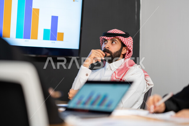 تحقيق الاهداف المالية للشركة، صورة علوية عامودية مقربة لاجتماع رجال فريق عمل عربي خليجي سعودي، مفهوم الإدارة المتعاونة، جمع بيانات البورصه وسوق الأسهم, دراسة و تحليل الاحصائيات و الرسوم البيانية, دمج التكنولوجيا مع العمل.
