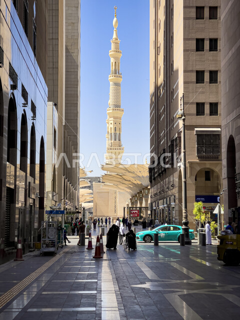 المباني والفنادق في الفناء الخارجي للمسجد النبوي الشريف، في المدينة المنورة في المملكة العربية السعودية، المظلات الالكترونية الكبيرة، مأذنة مسجد رسول الله، معالم واماكن اسلامية دينية مقدسة