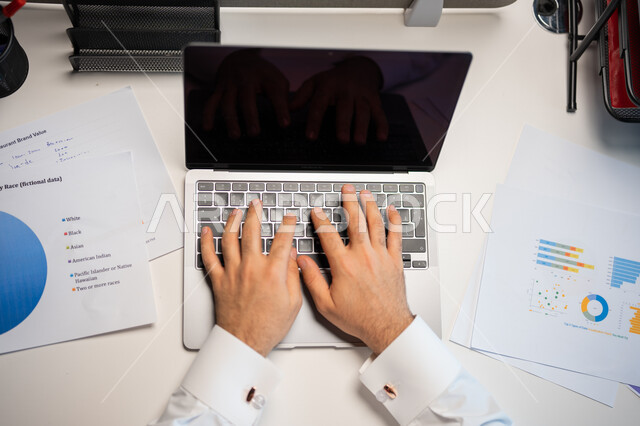 تطوير استراتيجية العمل وخطة النمو, مراقبة نزول وصعود البورصة والأسهم المالية، صورة علوية عامودية لموظف ينجز مهام العمل باستخدام الحاسب المحمول، قسم التحليلات والإحصائيات البيانية، بيانات خسائر وارباح الشركة, شاشة لابتوب سوداء فارغة.