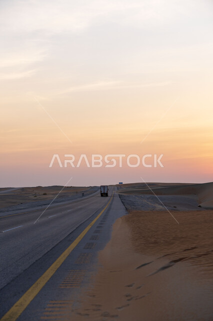 Asphalt road between sand dunes, desert nature at sunset, sand dunes, tourist desert areas, desert travel road