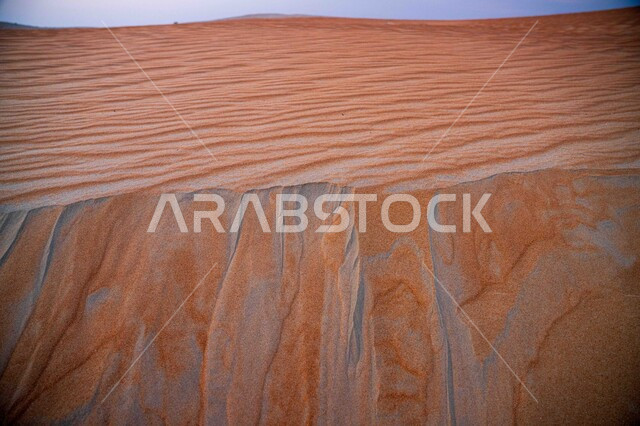 المناظر الطبيعية في البيئة الصحراوية ، صورة مقربة لتشكيلات الرمال الذهبية الناعمة في صحراء الربع الخالي في المملكة العربية السعودية، التلال و الكثبان الرملية, خلفية الطبيعه الصحراوية