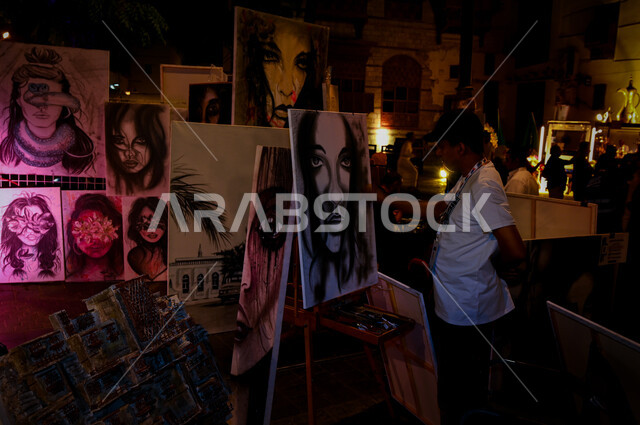 A plastic artist in the drawing corner within the Jeddah Festival, festivals and events in the Kingdom of Saudi Arabia, an exhibition of artistic drawings and paintings, a hobby of drawing and handicrafts.