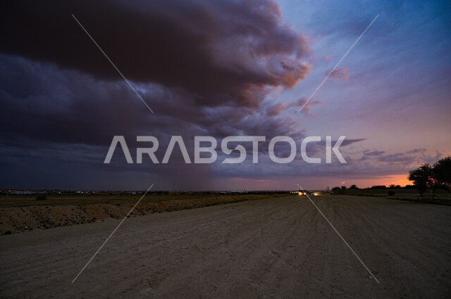 طرق السفر المعبدة و الشوارع الكبيرة في الرياض, الضواحي في وقت الليل في المملكة العربية السعودية, سماء مليئة بالغيوم المحملة بالأمطار.