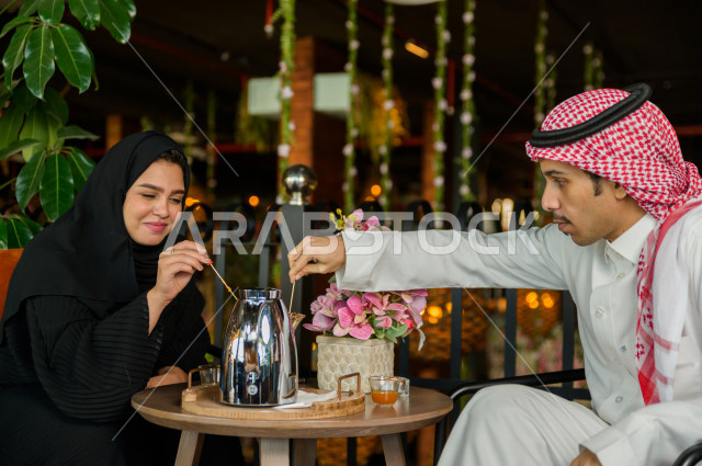 زوجان عربيان خليجيان سعوديان يجلسان في المطعم بأجواء رائعة ، يقضيان وقتهما سويا للاستمتاع و الترفيه عن انفسهم ، قضاء أوقات ترفيهية ممتعة ، جلسات فريدة و مميزة ، مطاعم و كافيهات في السعودية