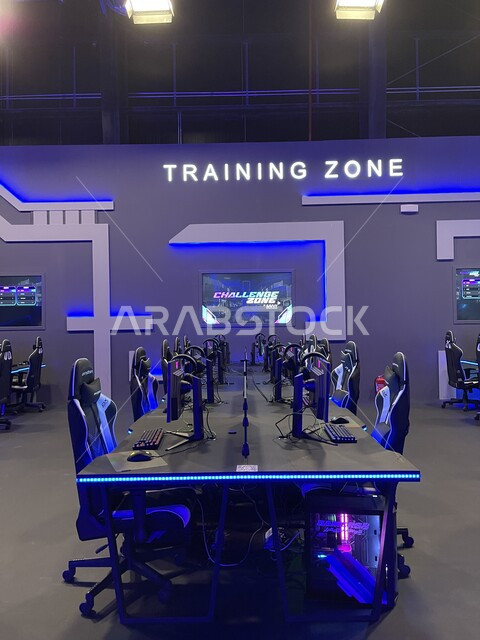 صورة مقربة لطاولة مع مجموعه من الكمبيوترات وكراسي اللعب الإحترافيه، أجهزة حاسوب الجيمرز المتطورة للألعاب الإلكترونية، فعاليات موسم الجيمرز ٨ في بوليفارد الرياض، منطقة التحديات والبطولات بين اللاعبين المحترفين، التسليه والترفيه بالتقنيه والتكنولوجيا الحديث