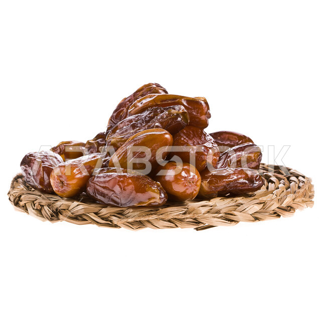 صحن مليء بالتمر السكري الرطب من نخيل المملكة العربية السعودية, بورتريه مقرب لطبق من التمر المكنوز بجانبه سبحة, تمور المملكه العربيه السعوديه والمدينه المنوره، وجبة ذات قيمة غذائية عالية، ضيافة رمضانية صحية، خلفية بيضاء