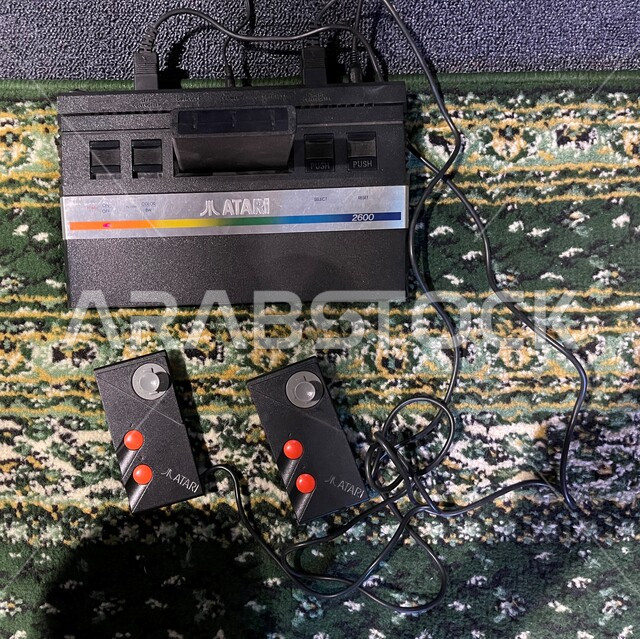 قضاء الأوقات الممتعة في ممارسة الأنشطة الترفيهية، صورة مقربة لجهاز أتاري مع يد التحكم الخاصة، أجهزة الألعاب الإلكترونية القديمة، التحديات و المنافسات و اللعب مع الأصدقاء و العائلة، ذكريات من الماضي، جيمز شبابيه عائليه مسليه