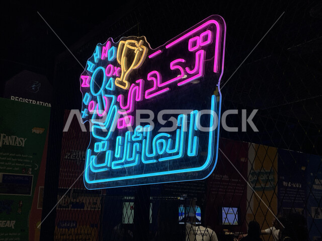صورة من الجانب للوحة إعلانية بارزة، نيون مضيء لكلمة تحدي العائلات في بوليفارد الرياض سيتي بموسم الجيمرز ٨، أجهزة، أماكن سياحية مشهورة في المملكة العربية السعودية، التحديات والمنافسات واللعب مع الأصدقاء والعائله، جيمز شبابيه ممتعه