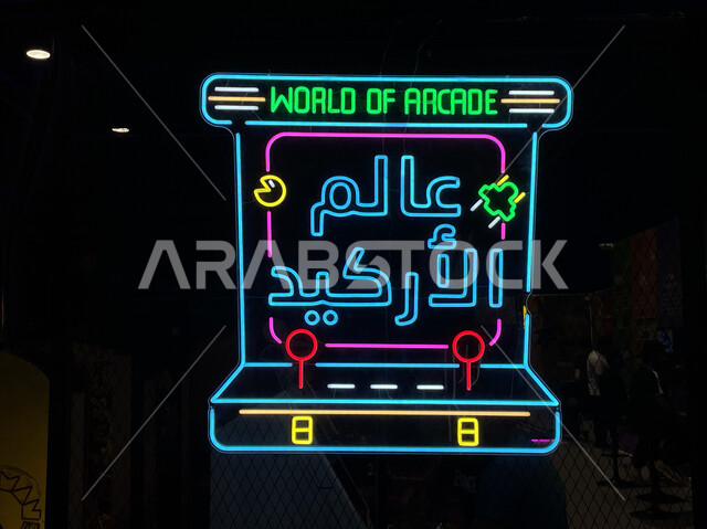 Challenge and competition among Saudi Gulf players, a close-up of a prominent billboard, a neon light for the word arcade world, playing in electronic games halls in the Gamers 8 season in Riyadh Boulevard, spending enjoyable times in recreational activit