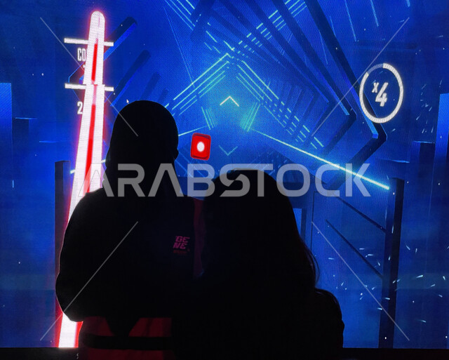 صوره ظليه لمجموعه من الزوار يستمتعون بلعبة (بيت سايبر) في منطقة التحديات (تشالينج زون), الألعاب الإلكترونيه ثلاثية الأبعاد المتطوره, جيمز شبابيه تفاعليه في موسم الجيمرز 8 في بوليفارد الرياض سيتي، ممارسة الأنشطة الترفيهية السياحية، جذب السياح إلى السعودية