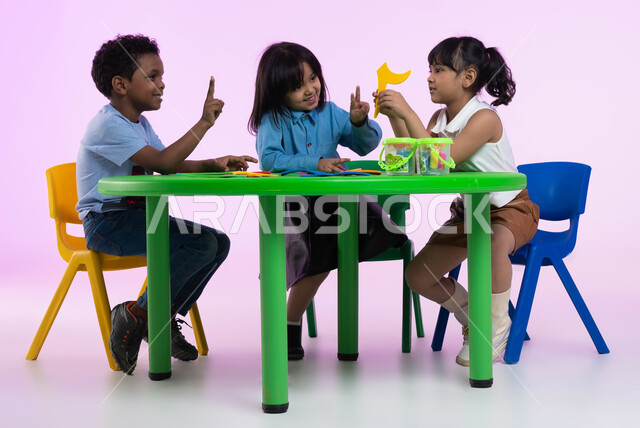 نشاطات ترفيهية وتعليمية تساعد على تنمية القدرات الفكرية، المشاركة والتعاون بين أطفال الروضة في تعلم الرياضيات، تعلم الأرقام والأعداد العربية وأشكالها، بوتريه لأطفال عرب خليجيين سعوديين يرتدون الزي الكاجوال يتعلمون الحساب، خلفية وردية.