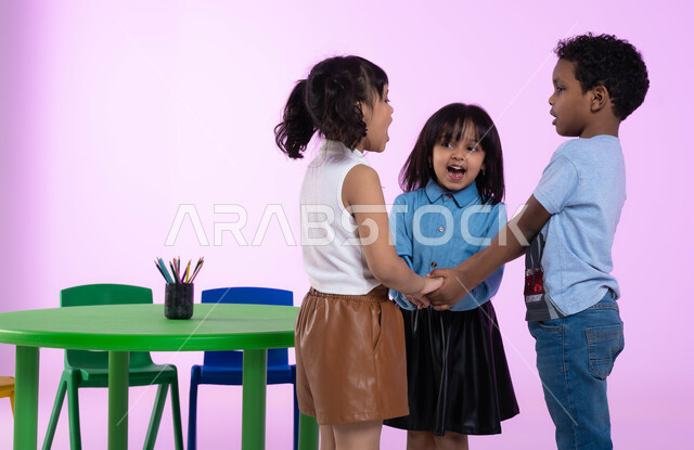 تعليم وإبداع وتنمية مهارات في رياض الأطفال، قضاء أوقات ممتعة ومفيدة في الروضة، بورتريه لأطفال عرب خليجيين سعوديين يرتدون الزي الكاجوال يلعبون ويمرحون، إيماءات تدل على الفرح والسعادة، خلفية وردية.