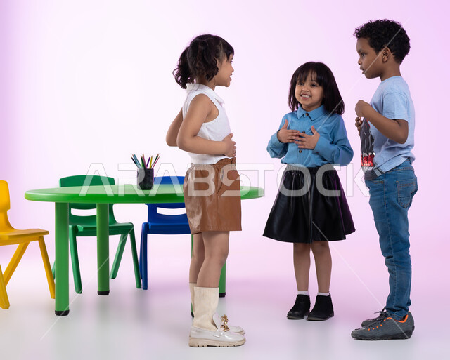 دمج اللعب بالتعليم في رياض الأطفال، قضاء أوقات ممتعة ومفيدة في الروضة، بورتريه لأطفال عرب خليجيين سعوديين يرتدون الزي الكاجوال يلعبون ويمرحون، إيماءات تدل على الفرح والسعادة، خلفية وردية.