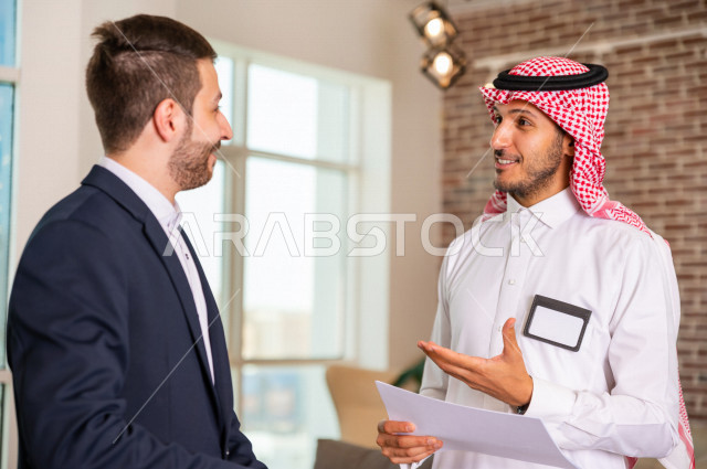 رجل اعمال سعودي خليجي في مقر الشركة مع السكرتير الخاص فيه يدير المهام اليومية ،ادارة الاعمال داخل مقر الشركة ، شركاء عمل ، متابعة الاهداف والخطط ، شركة سعودية ، بيئة العمل