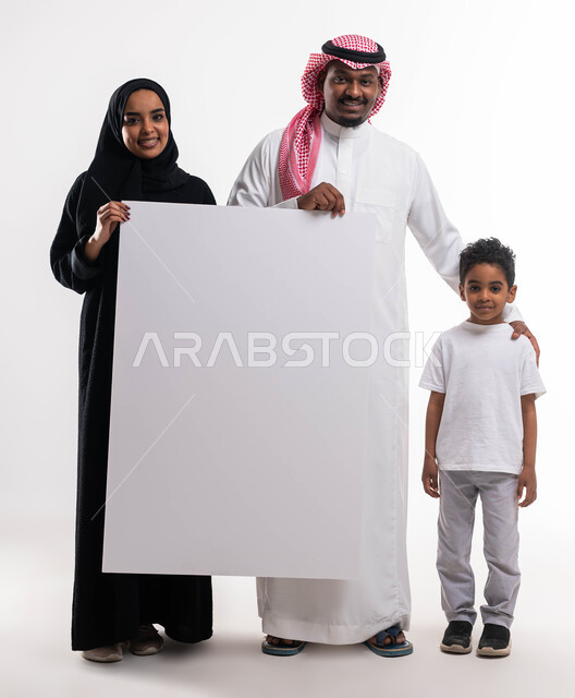 لوحة فنية اعلانية، تلبية الاحتياجات المنزلية, بورتريه لعائلة عربية خليجية سعودية مع الابن يحملان بيدهما لوح أبيض كبير فارغ، صورة الجسم بالطول الكامل، ايماءات تدل على السعادة، خلفية بيضاء .
