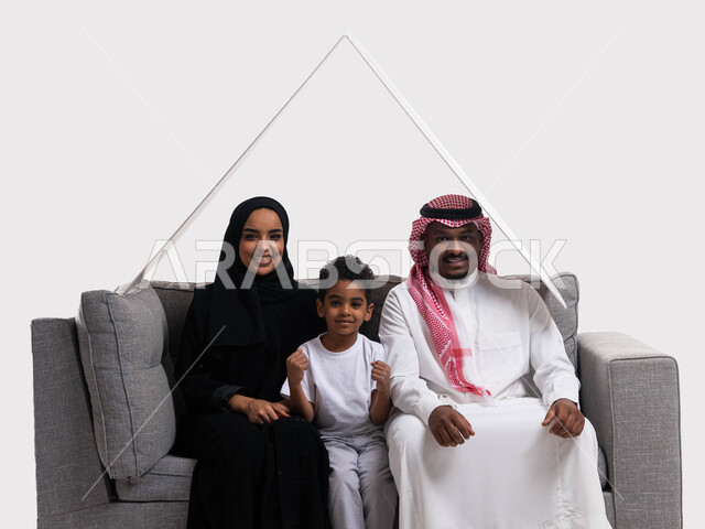 ايماءات تدل على التشجيع و السعادة، الجلوس على كنبة رمادية في غرفة المعيشة ومشاهدة المبارايات ،بورتريه لعائله عربيه سعوديه خليجيه مكونه من الاب والام والابن يضعون فوق رأسهم لوح ابيض، ارتداء الزي السعودي التقليدي , خلفية بيضاء